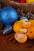 Vánoční mandarinky a vánoční hračky na dřevěný stůl detail