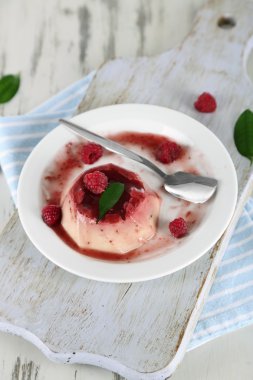 Panna cotta ahşap zemin üzerinde frambuaz sos ile