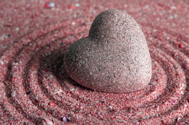 Gri zen stone kum arka plan üzerinde kalp şeklinde