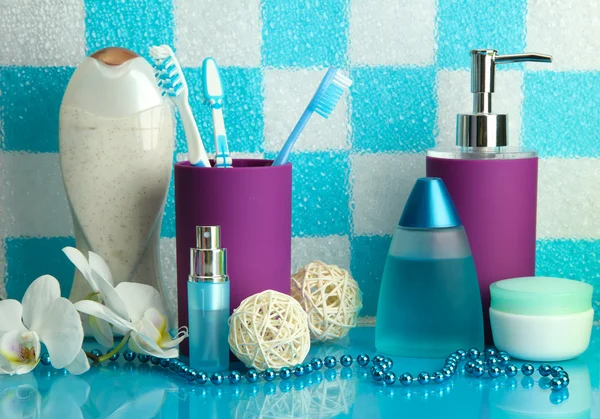 Bath accessories on shelf in bathroom on blue tile wall background — Stock Photo, Image