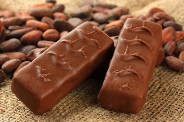 Deliciosas barras de chocolate com grãos de cacau fechar — Fotografia de Stock