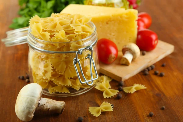 Pasta with oil, cheese and vegetables on wooden table close-up — Stock Photo, Image