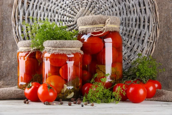 Tomates enlatados e frescos saborosos na mesa de madeira — Fotografia de Stock