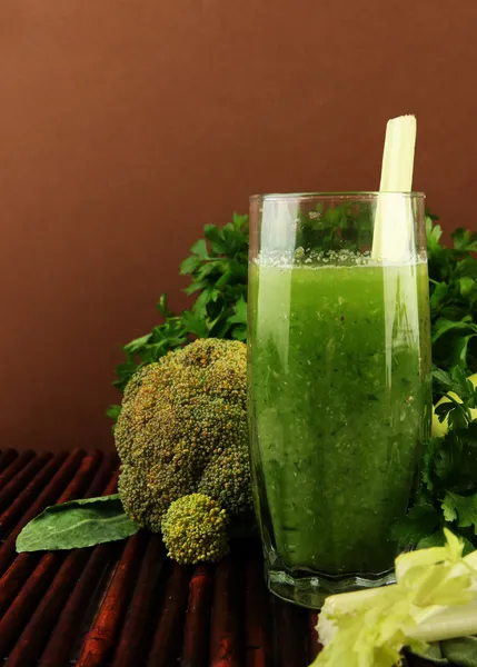 绿色蔬菜汁和蔬菜在竹凉席上棕色背景上的眼镜 — 图库照片