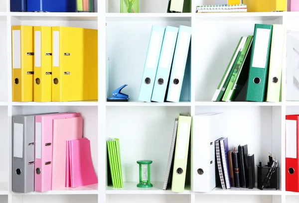 Prateleiras de escritório branco com pastas e artigos de papelaria diferentes, close-up — Fotografia de Stock