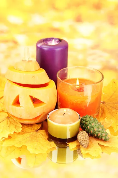 Samenstelling voor halloween met pompoen en kaarsen op oranje achtergrond — Stockfoto