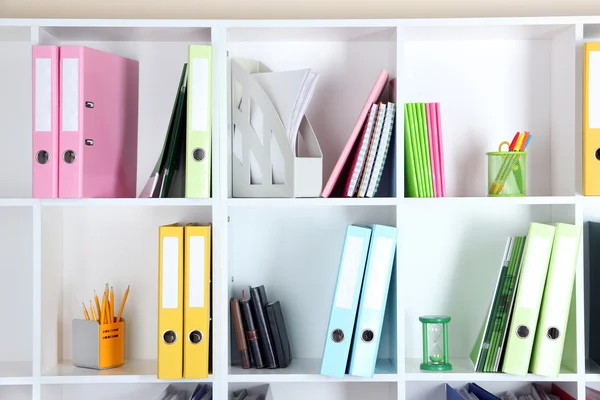Prateleiras de escritório branco com pastas e artigos de papelaria diferentes, close-up — Fotografia de Stock