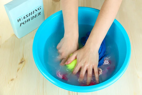 Hand washing in plastic bowl on wooden table close-up — Stock Photo, Image