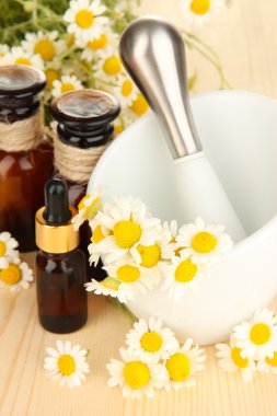 esans ve harç ahşap masa üzerinde papatya çiçeği.