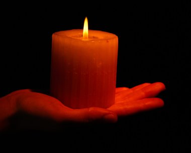 Yanan Mum el üstünde siyah izole