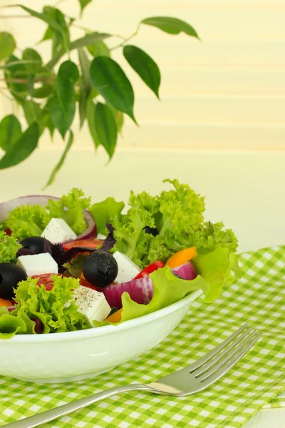 明るい背景上のテーブルに皿の上のギリシャ風サラダ — ストック写真