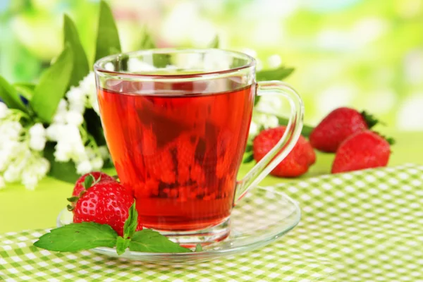 Delicioso té de fresa en la mesa sobre fondo brillante —  Fotos de Stock