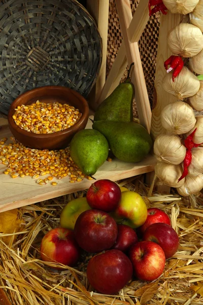 Bowl of corns with pears and apples on shelf on wicker background — Stock Photo, Image