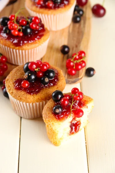 Tasty muffins with berries on white wooden table — Stock Photo, Image