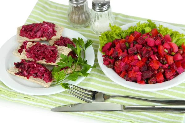 Beet salad on toasts and in plates on board on napkin isolated on white — Stock Photo, Image