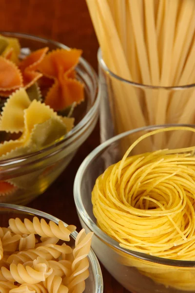 Diversi tipi di pasta sulla tovaglia a righe — Foto Stock