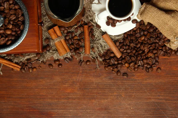 Grãos de café, turk metal e moinho de café em fundo de madeira com espaço de cópia — Fotografia de Stock