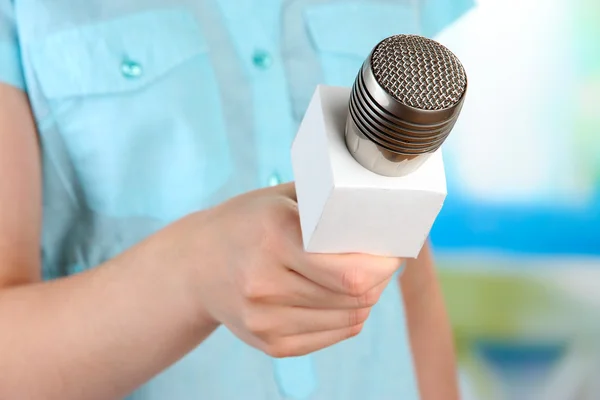 Femme avec microphone sur fond de pièce — Photo