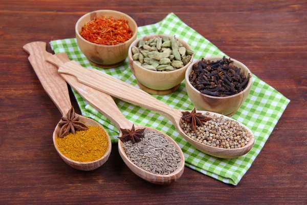 Various spices and herbs on wooden background — Stock Photo, Image