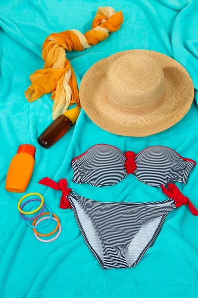 Badeanzug und Strandartikel auf hellblauem Hintergrund — Stockfoto