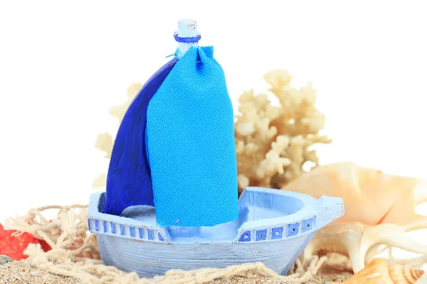 Синій іграшковий корабель на піску ізольований на білому — стокове фото