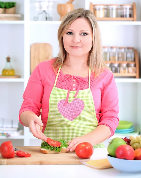 Feliz mulher sorridente na cozinha preparando sanduíche — Fotografia de Stock