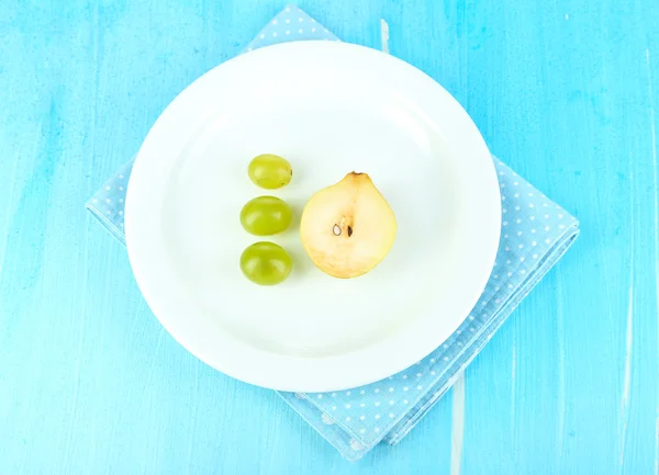 Small portion of food on big plate on wooden table close-up — Stock Photo, Image