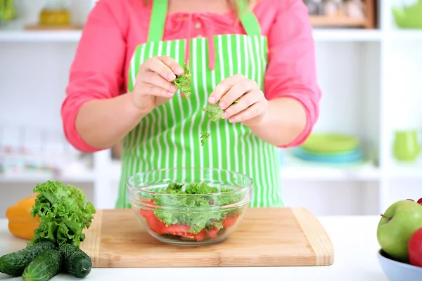 Happy smiling woman in kitchen preparing vegetable salad — Stock Photo, Image