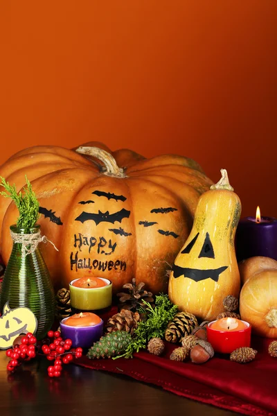 Composizione per Halloween con zucche e candele su sfondo arancione — Foto Stock