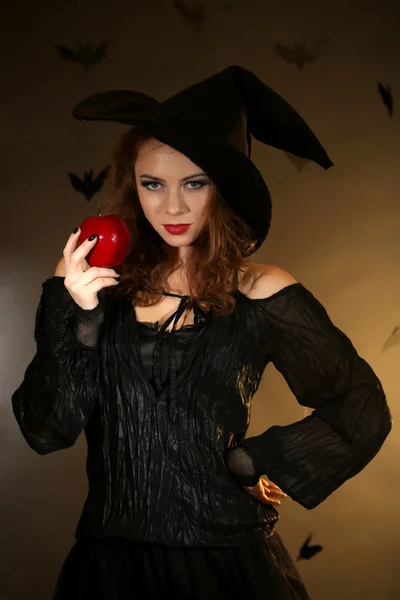 Bruja de Halloween con manzana sobre fondo oscuro —  Fotos de Stock