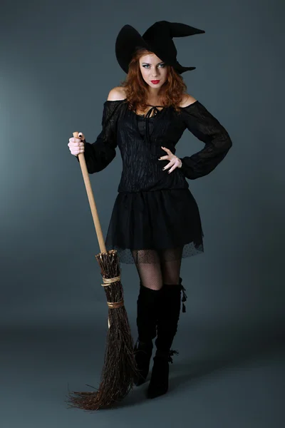 Halloween witch with broom on gray background — Stock Photo, Image