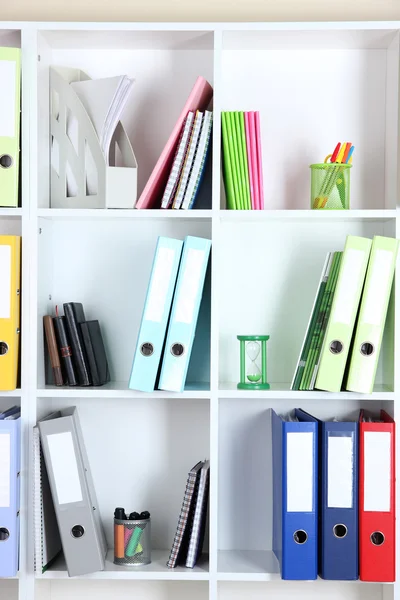 White office shelves with folders and different stationery, close up Stock Photo