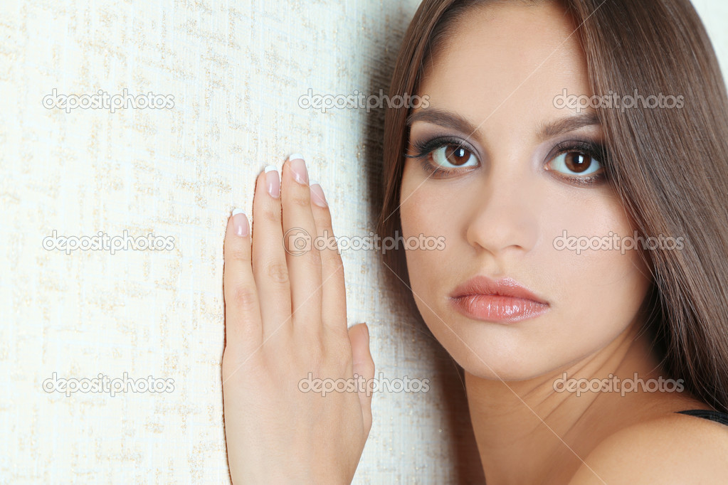 Lonely sad woman standing near wall