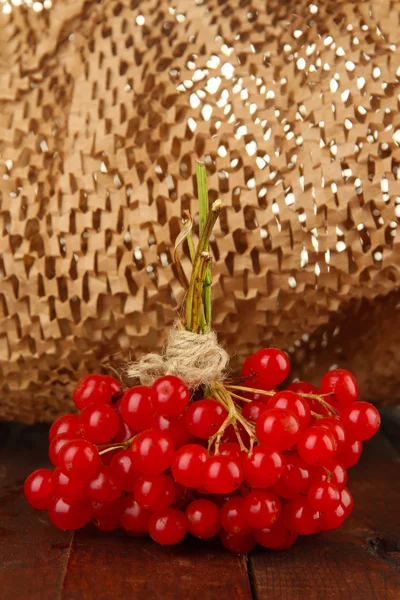 Rode bessen van planten van viburnum op tafel op bruine achtergrond — Stockfoto