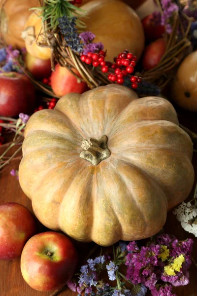 Herbstliche Komposition aus Äpfeln, Kürbissen, Blumen und trockenen Zweigen auf Holztisch in Großaufnahme — Stockfoto