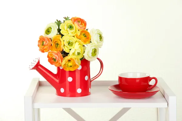 Blumen mit Tasse Tee auf weißem Regal auf grauem Hintergrund — Stockfoto