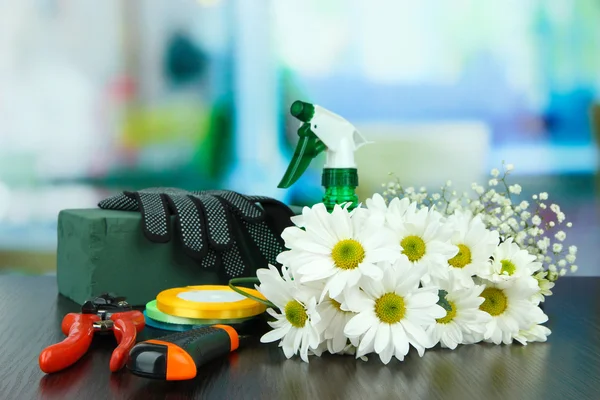 Composición con herramientas de floristería en la mesa sobre fondo brillante —  Fotos de Stock