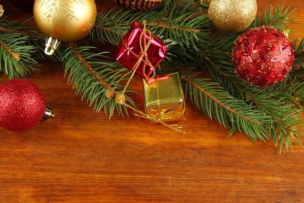 Belle decorazioni natalizie su abete su sfondo di legno — Foto Stock