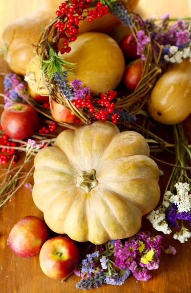 Composición otoñal de manzanas, calabazas, flores y ramas secas sobre una mesa de madera —  Fotos de Stock