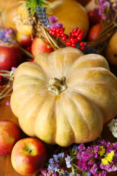 Podzimní složení jablka, dýně, květin a suché větve na dřevěný stůl detail — Stock fotografie