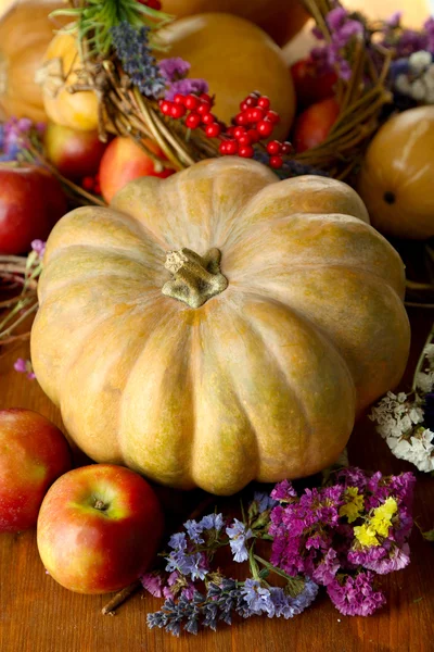 Herbstliche Komposition aus Äpfeln, Kürbissen, Blumen und trockenen Zweigen auf Holztisch in Großaufnahme — Stockfoto