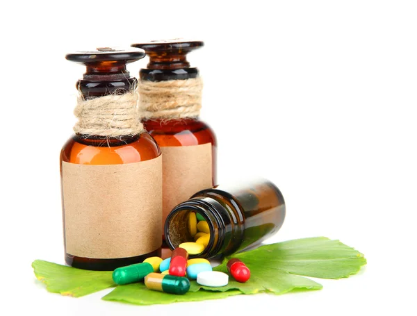 Ginkgo biloba hojas y frascos de medicamentos con pastillas aisladas en blanco —  Fotos de Stock