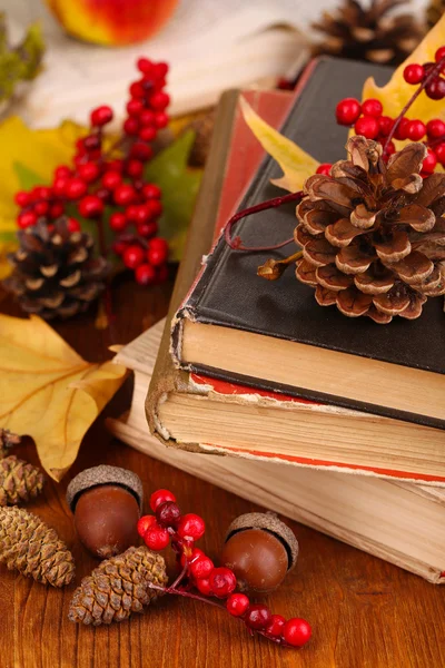 Books and autumn leaves on wooden table close-up — Stock Photo, Image