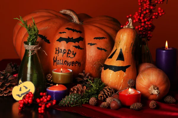 Samenstelling voor halloween met pompoenen en kaarsen op oranje achtergrond — Stockfoto