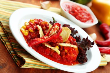 biberli Mısır carne - geleneksel Meksika yemeği peçeteye ahşap arka plan üzerinde beyaz plaka üzerinde