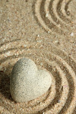 Gri zen stone kum arka plan üzerinde kalp şeklinde
