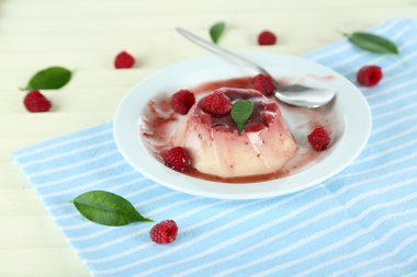 Panna cotta ahşap zemin üzerinde frambuaz sos ile