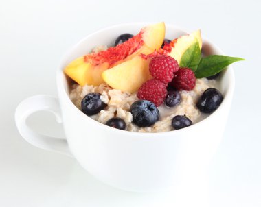 havermout in cup met bessen geïsoleerd op wit