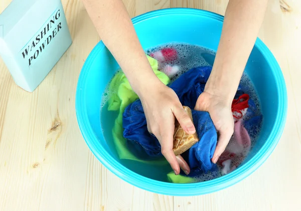 Hand washing in plastic bowl on wooden table close-up — Stock Photo, Image