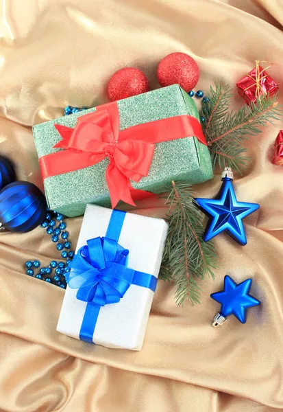 Красивые яркие подарки и рождественский декор, на шелковой ткани — стоковое фото